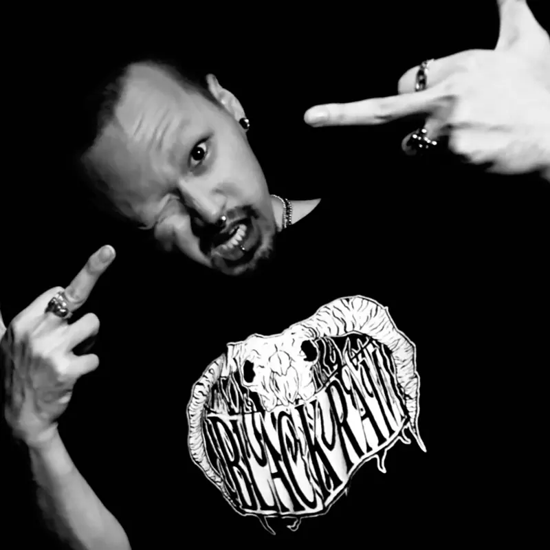 黒いTシャツを着て中指を立てるメンバー