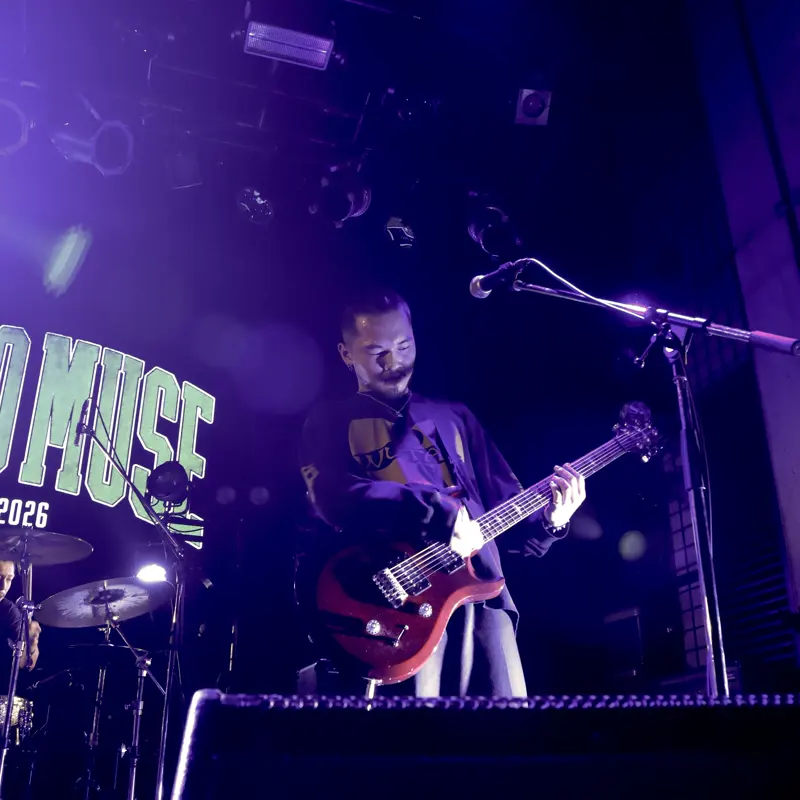 KYOTO MUSE でのライブ。紫の照明の中でギターを弾くメンバー
